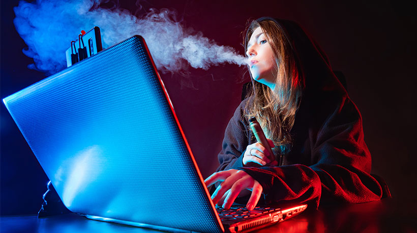 A girl blogger smokes a VAPE in front of the screen. The girl is