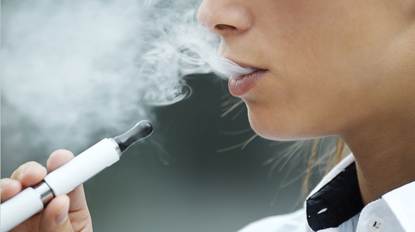 closeup of woman smoking electronic cigarette outdoor